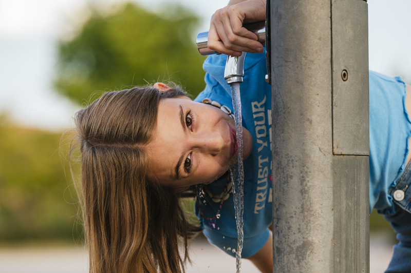 the-very-happy-girl-drinking-water-at-the-fountain-2023-11-27-05-11-01-utc (1)